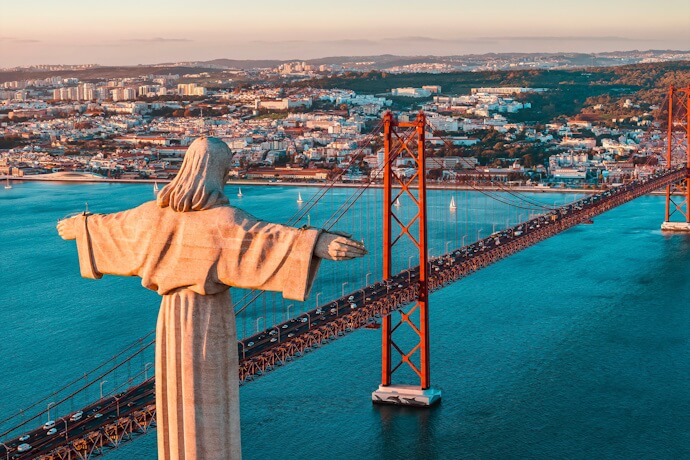 Aerial view of the Christ the King monument and the 25 de Abril Bridge spanning the Tagus River, in Almada.