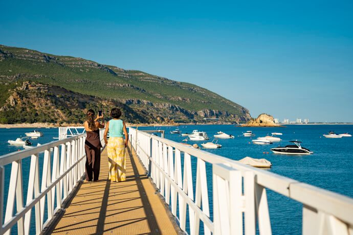 Mother and daughter taking a picture at Portinho da Arrábida, in Portugal