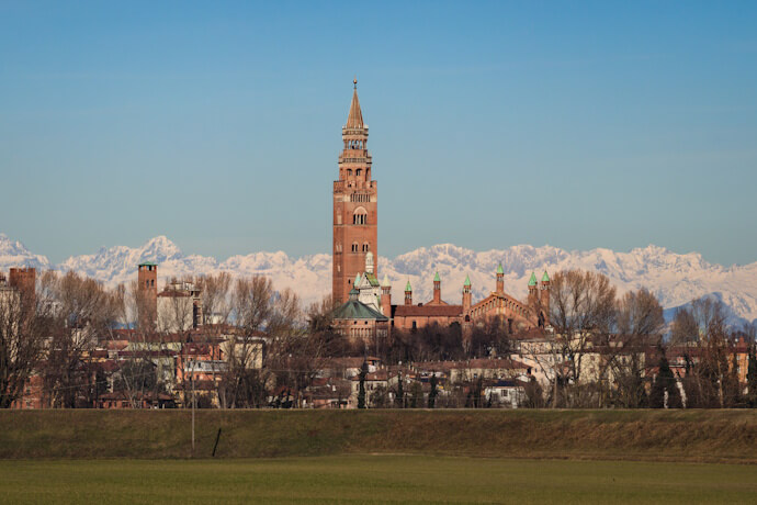 Cremona Cathedral and Torrazzo tower, Italy, against the snowy Alps