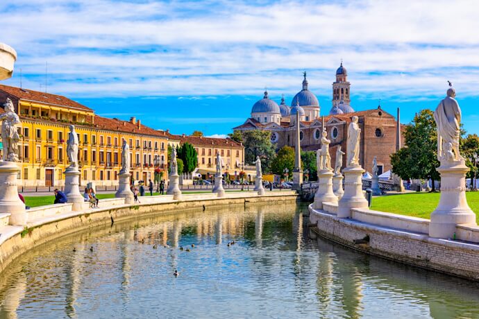 Prato della Valle canal and statues in Padua, with a view of the Basilica.