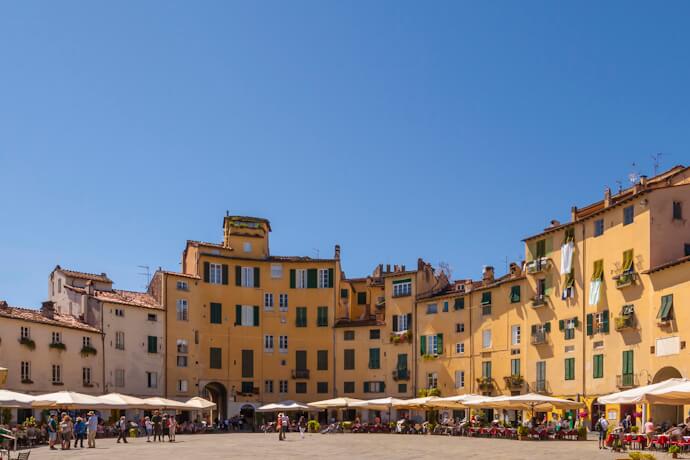 People in Piazza Anfiteatro in Lucca on a sunny day