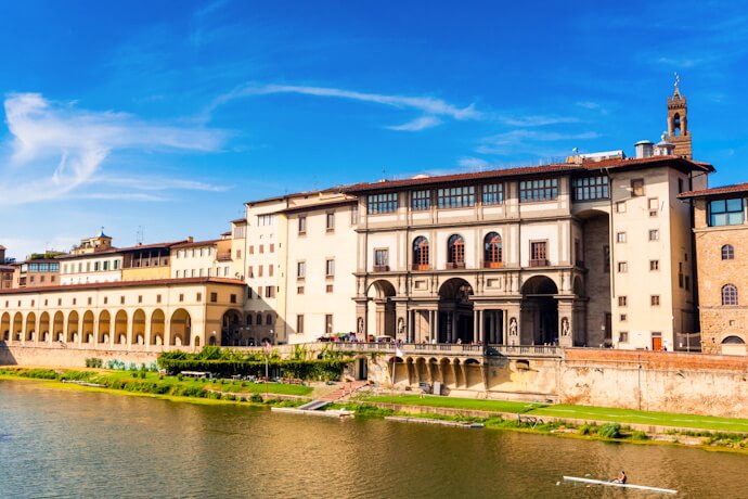 Uffizi Gallery Florence viewed from Arno River under blue sky