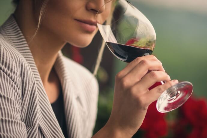 Woman tasting a glass of red wine in the Douro Valley