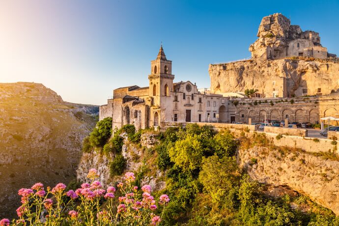 Ancient stone cave homes in Matera and terraces cascading down the hillside in the Sassi district.