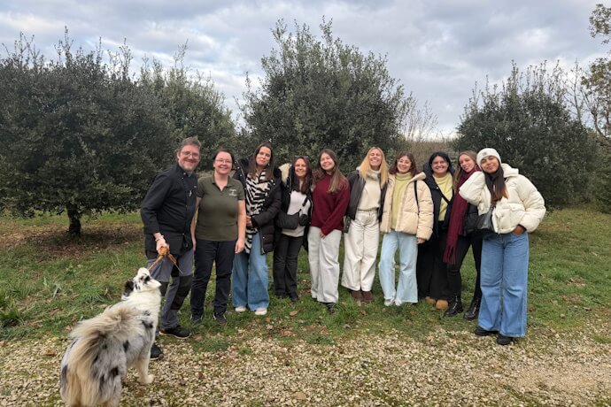 TourTailors team group photo outdoors in the Dordogne countryside, standing among trees and fields during a rural visit.
