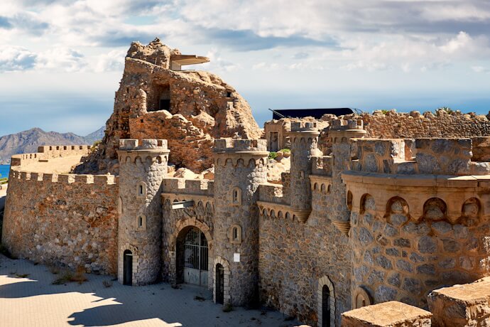 Historic stone fortress in Murcia set on a hillside, featuring robust walls, towers, and views stretching toward the surrounding landscape.