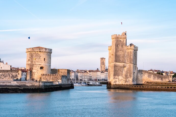 Historic towers guarding the Old Port entrance in La Rochelle, a famous medieval harbor city on France’s Atlantic coast