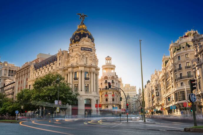 Iconic Metropolis Building on Madrid’s Gran Vía, framed by elegant architecture and glowing in late afternoon light.