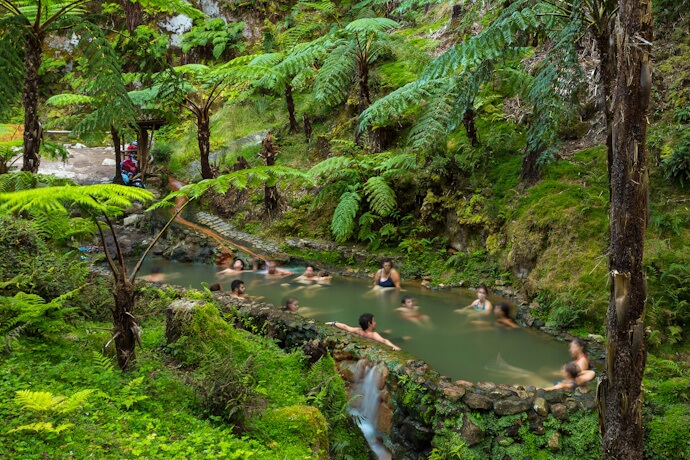 Thermal bathing pools surrounded by lush forest at Caldeira Velha in São Miguel, Azores.
