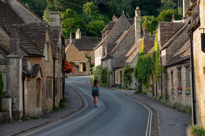 Quiet Cotswolds village street lined with stone cottages.