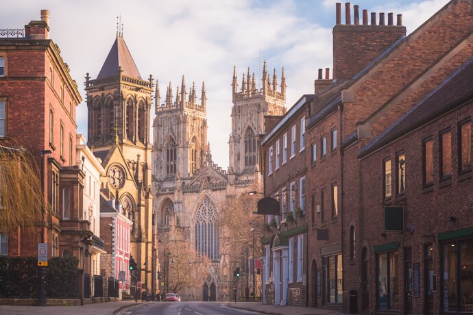 York Minster framed by historic buildings along a city street.