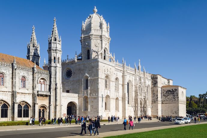 People visiting Jerónimos Monastery in Lisbon, Portugal, with Gothic and Manueline architecture