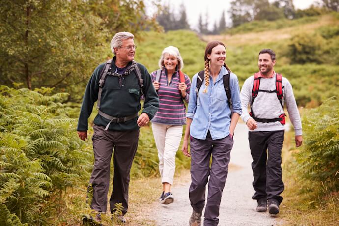 Group hiking through lush countryside in the United Kingdom, enjoying scenic nature trails