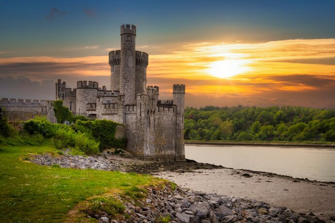 Blackrock Castle, in Cork, a striking 16th-century fortress-turned-observatory, overlooking the River Lee and glowing under a golden sunset.
