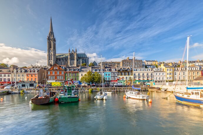 Cobh, a charming harbor town with colorful waterfront houses and the impressive St. Colman’s Cathedral rising above.