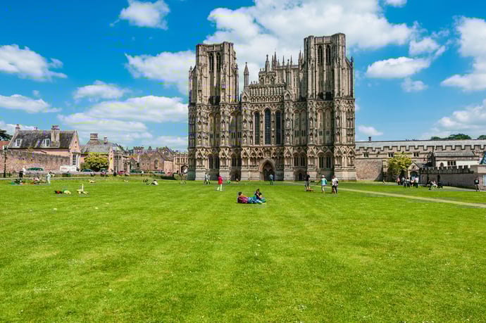People enjoying a sunny day outside Wells Cathedral