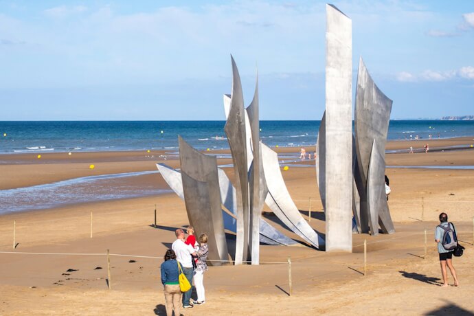 People admiring The Brave sculpture in Omaha Beach, Normandy