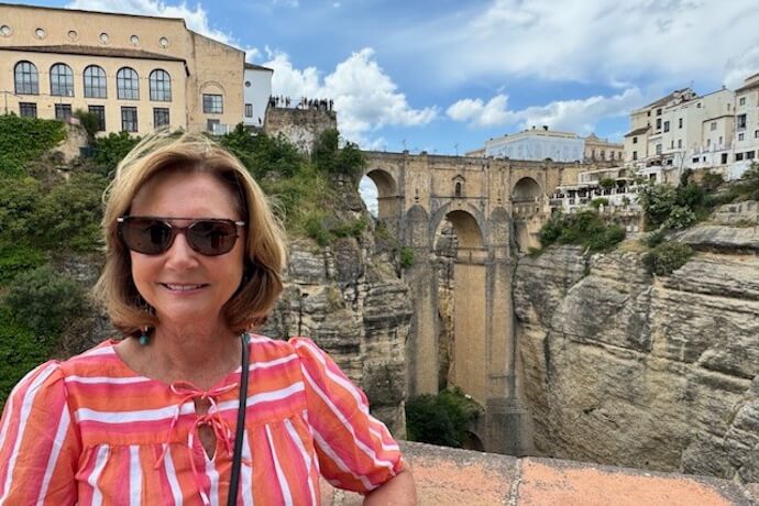 Woman taking a picture with the Puente Nuevo in Ronda on the background