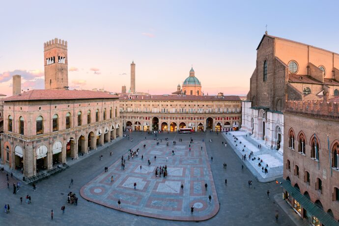 Aerial view of Bologna’s Piazza Maggiore at sunset, with the historic buildings.