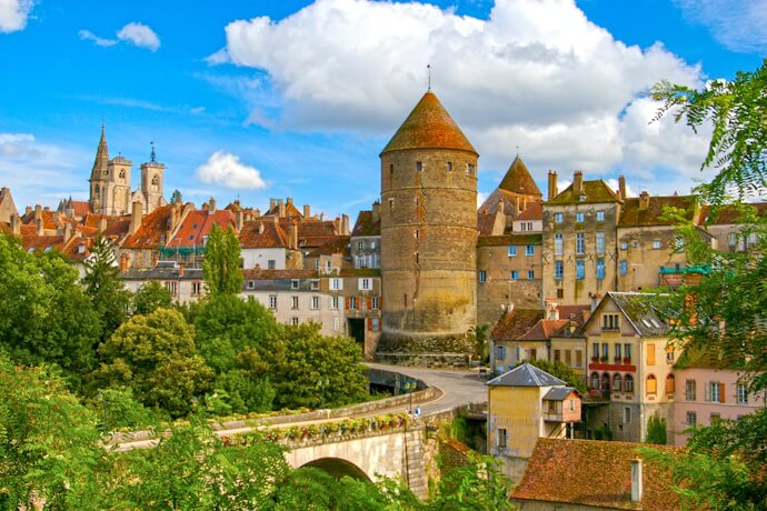 Medieval town with stone towers and rooftops in Burgundy, France.