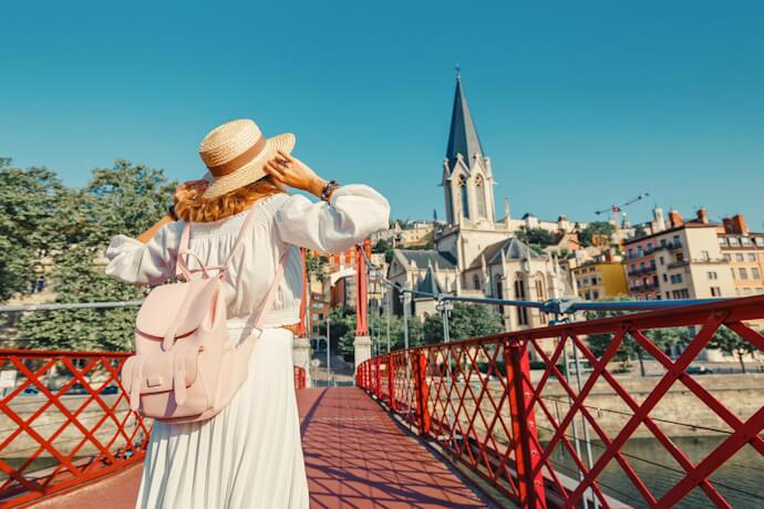 Traveler crossing a pedestrian bridge over the Saône in Lyon