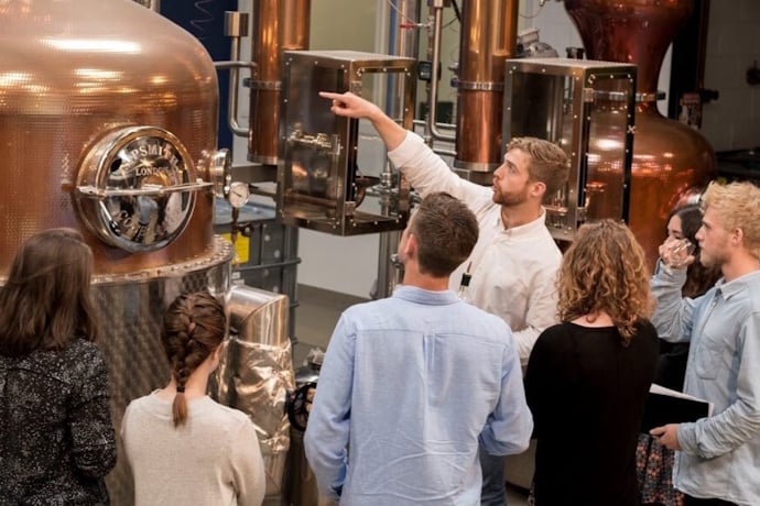 Gin distillery tour in London with guide explaining copper stills