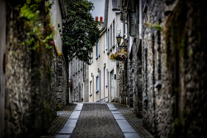 Narrow cobblestone street lined with old stone buildings in Kilkenny, Ireland.