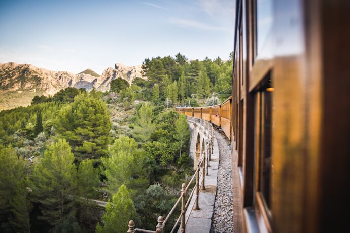 Scenic train trip through a green mountainous landscape