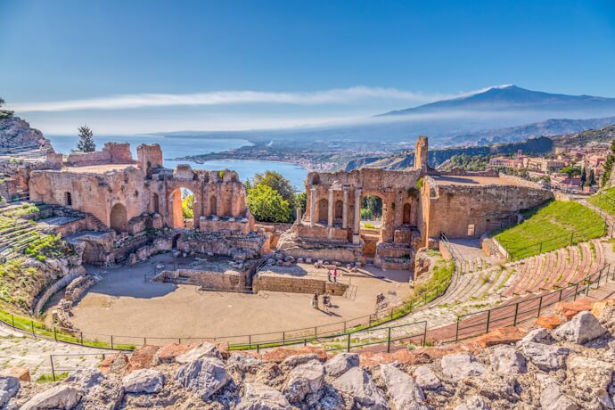 Ancient Greek theatre in Taormina, Sicily, with Mount Etna and coastline views in the background