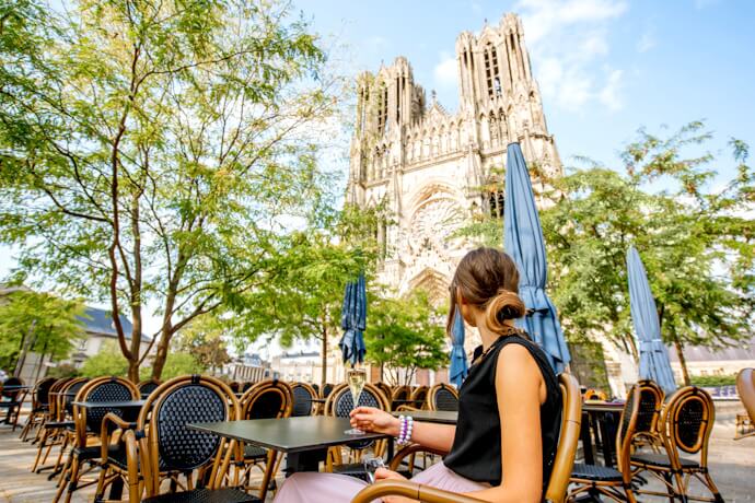 Outdoor café terrace in Reims with views of the Gothic cathedral, reflecting France’s café culture.