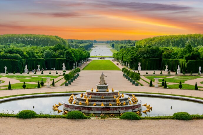 Grand fountains and formal gardens of the Palace of Versailles showcasing the grandeur of French royal heritage.