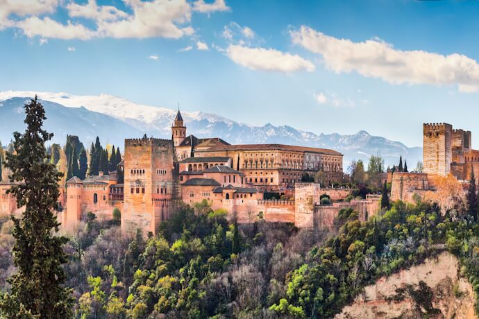 Alhambra palace and fortress overlooking Granada with Sierra Nevada mountains in the background