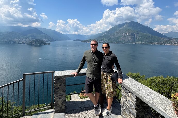 Couple standing on a scenic stone terrace overlooking Lake Como in Lombardy, Italy