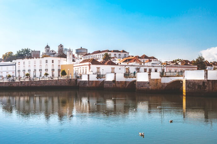 Whitewashed buildings and Roman bridge over the Gilão River in Tavira, Algarve.
