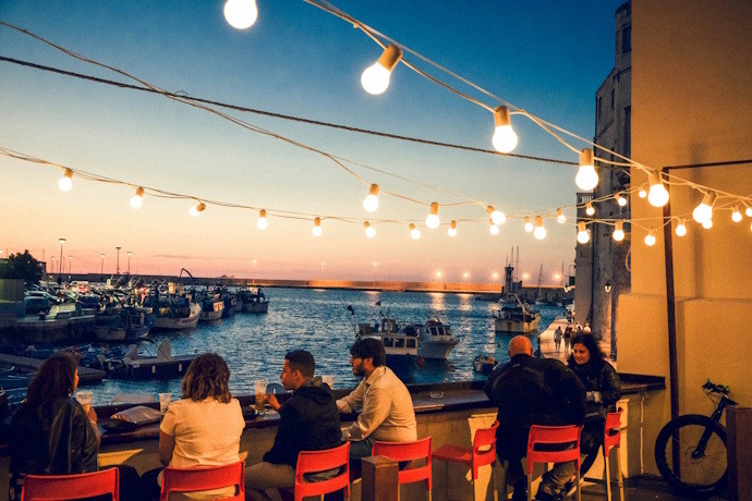 People having drinks on a terrace with a sea view in Bari