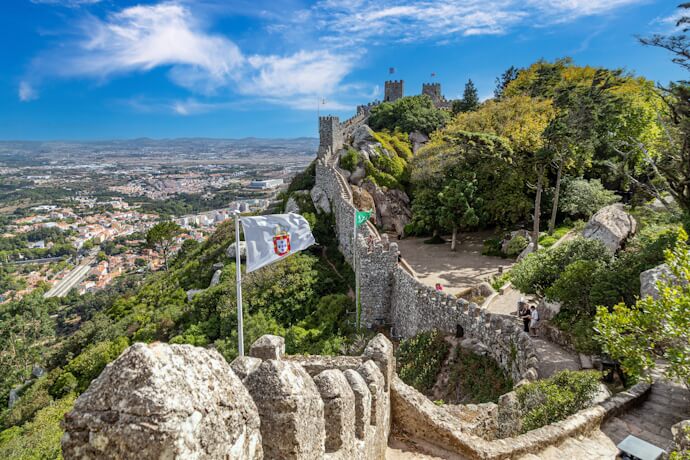 Moorish Castle in Sintra, Portugal, with stone walls winding along the hilltop and panoramic views of the surrounding landscape.
