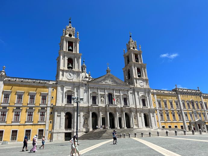 Mafra National Palace with its grand Baroque façade and twin bell towers in Mafra, Portugal.