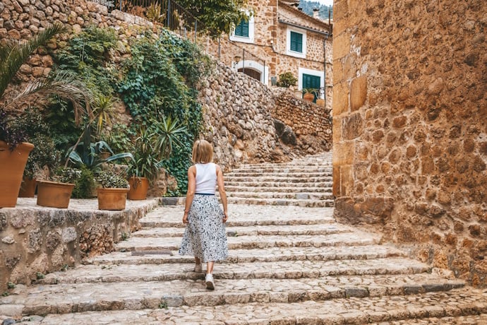 Woman walking through Valldemossa’s stone streets, Mallorca, Spain.