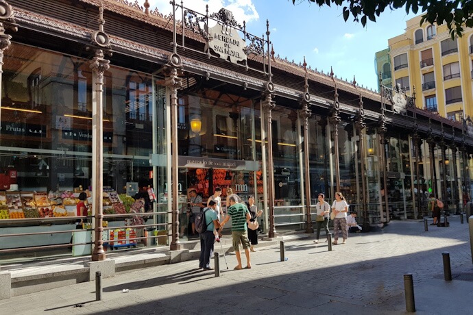Exterior view of Mercado de San Miguel in Madrid, Spain, with its iconic iron and glass architecture and lively atmosphere