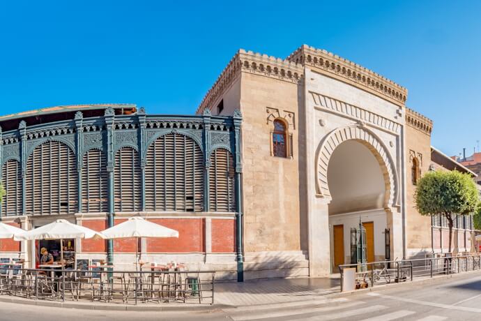 Exterior of Atarazanas Market in Málaga, Spain, on a sunny day, featuring its historic Moorish-style arch