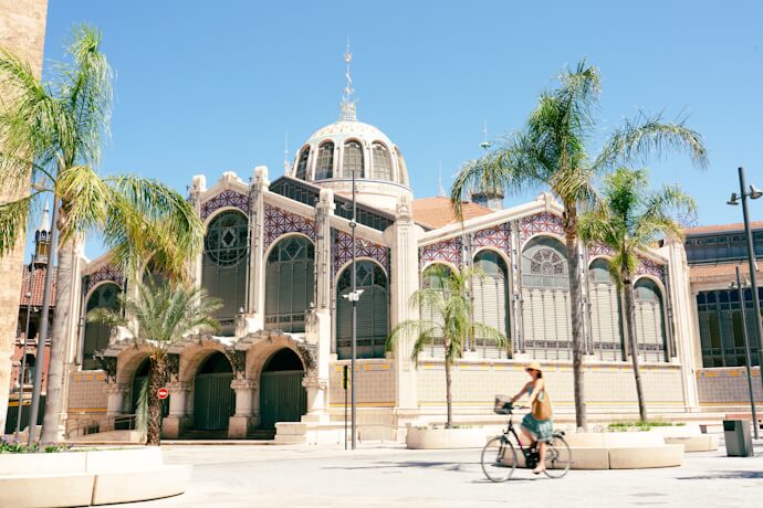 Exterior of Mercado Central in Valencia, Spain, showcasing its grand modernist architecture with decorative domes and ironwork details