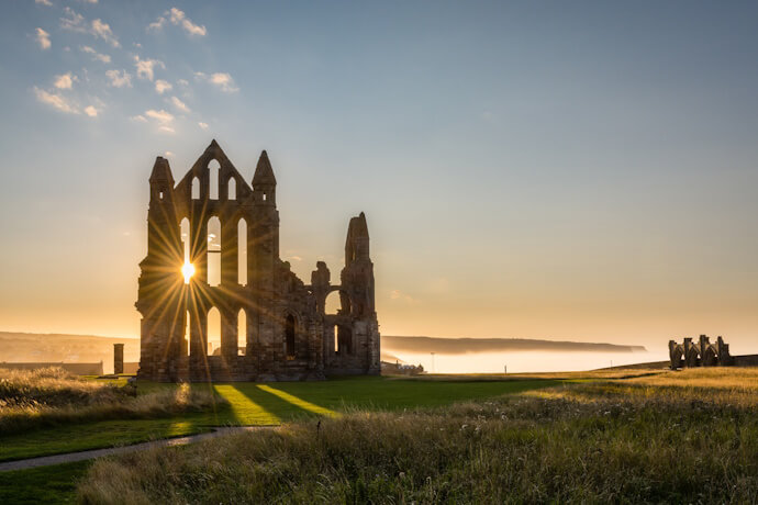 Whitby Abbey ruins illuminated by the setting sun, Yorkshire, England.