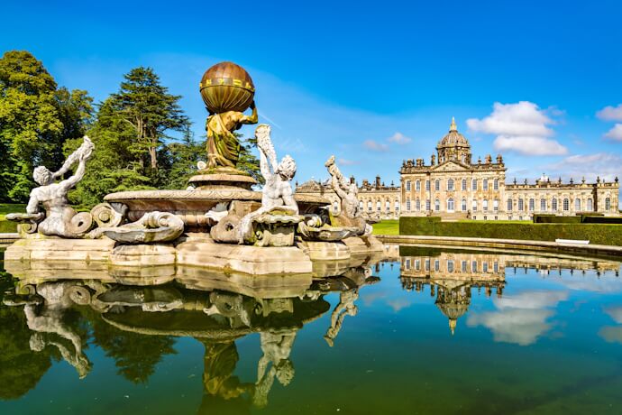 Castle Howard and the Atlas Fountain reflected in the water, Yorkshire, England.