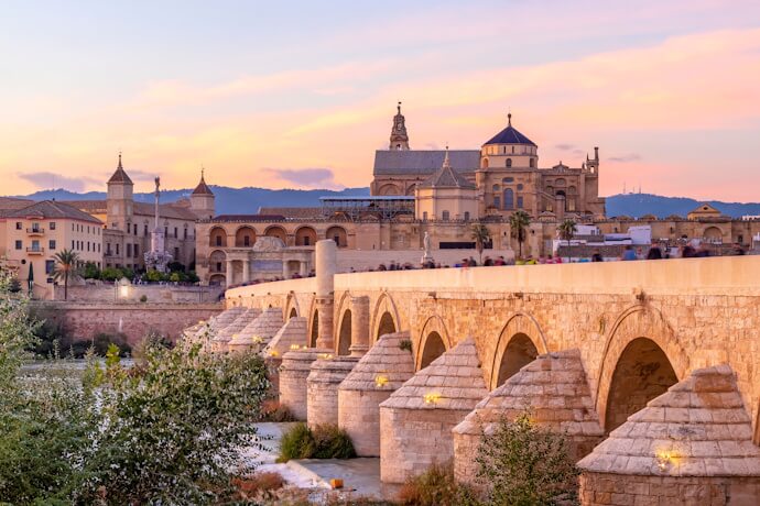 The Roman Bridge and Mosque-Cathedral of Córdoba at sunset, Spain.