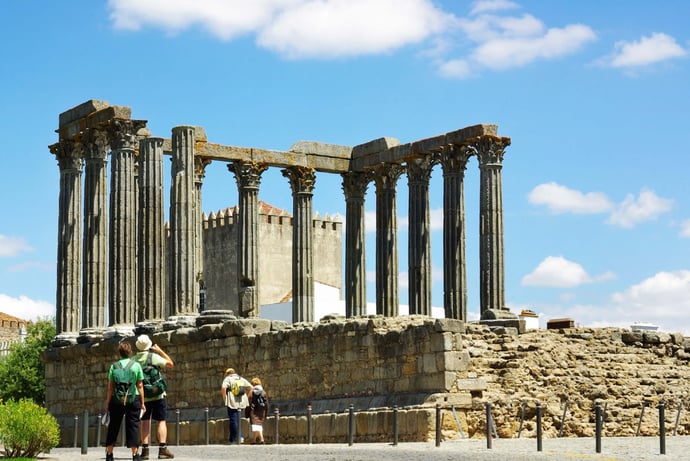 People passing by the famous Roman Temple in Évora, Portugal.