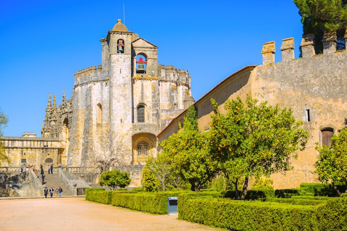 People visiting the Convent of Christ in Tomar Portugal with a garden view