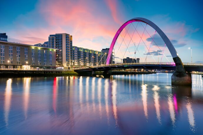 Clyde Arc bridge in Glasgow, Scotland, illuminated at sunset with reflections on the River Clyde