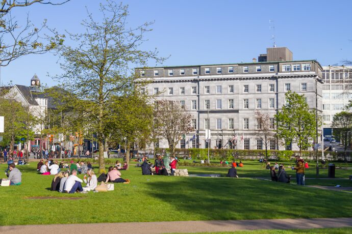 People relaxing in Eyre Square, Galway’s central gathering place and gateway to the vibrant Latin Quarter.