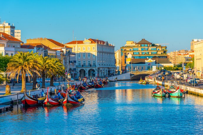 Canals lined with palm trees and Art Nouveau buildings welcome the colorful moliceiro boats of Aveiro.