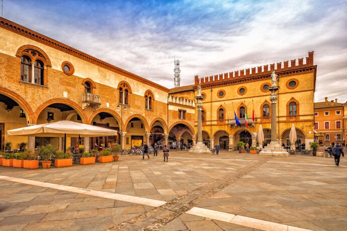 Historic piazza framed by elegant brick buildings in Ravenna.